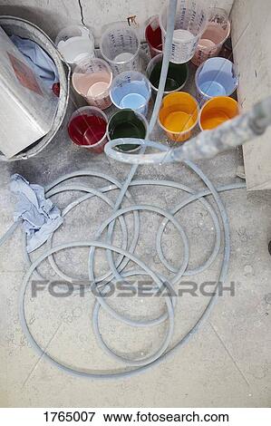 Stock Photo - Vibrant, multicolor paint in buckets and hose. Fotosearch