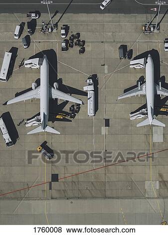 Stock Photo - View from above commercial airplanes being serviced, prepared on tarmac at airport. Fotosearch
