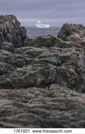 View of iceberg in sea through rocks on shore, Fogo Island, Newfoundland, Canada View Large Photo Image Stock Image - View of iceberg in sea through rocks on shore, Fogo Island, Newfoundland, Canada. Fotosearch