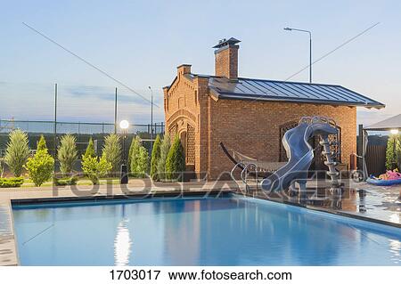 Water slide by swimming pool in back yard against sky during sunset View Large Photo Image Stock Photo - Water slide by swimming pool in back yard against sky during sunset. Fotosearch