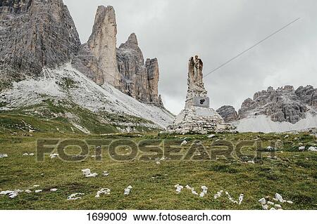 Stock Photo - Weathered statue by stack rocks against sky, South Tyrol, Italy. Fotosearch