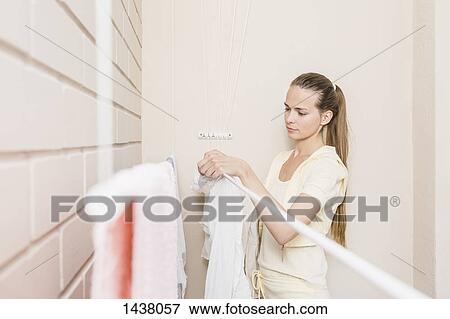Woman drying laundry at home View Large Photo Image Stock Photo - Woman drying laundry at home. Fotosearch