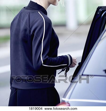 Woman getting into car View Large Photo Image Picture - Woman getting into car. Fotosearch