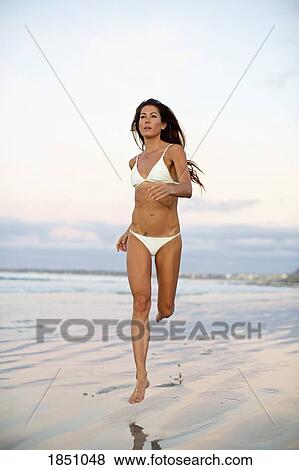 Woman in bikini running in wet sand on beach View Large Photo Image Stock Photo - Woman in bikini running in wet sand on beach. Fotosearch