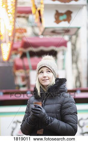 Woman in warm clothing drinking tea at carnival View Large Photo Image Stock Image - Woman in warm clothing drinking tea at carnival. Fotosearch