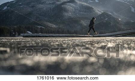 Woman in warm clothing walking on winter lake dock, Whistler, British Columbia, Canada View Large Photo Image Stock Photograph - Woman in warm clothing walking on winter lake dock, Whistler, British Columbia, Canada. Fotosearch