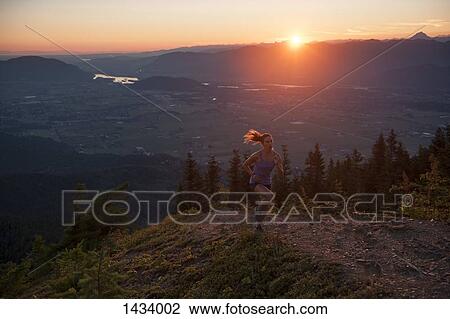 Woman jogging on mountain path during sunrise View Large Photo Image Stock Image - Woman jogging on mountain path during sunrise. Fotosearch