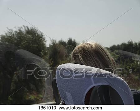 Woman on train relaxing, looking out sunny window View Large Photo Image Stock Image - Woman on train relaxing, looking out sunny window. Fotosearch