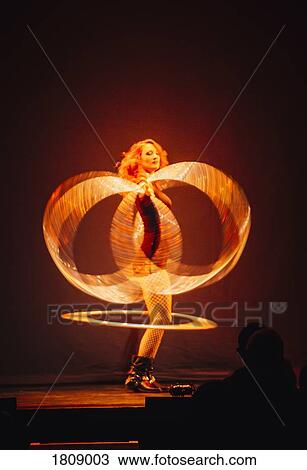 Woman performing on stage, spinning illuminated rings View Large Photo Image Stock Image - Woman performing on stage, spinning illuminated rings. Fotosearch