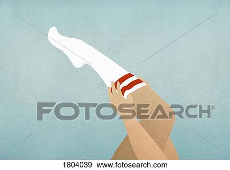 Stock Photo - Woman putting on knee high socks. Fotosearch