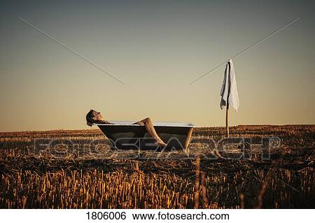 Woman relaxing in bathtub in rural field View Large Photo Image Stock Photograph - Woman relaxing in bathtub in rural field. Fotosearch