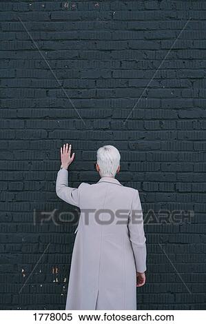 Woman standing and touching black brick wall View Large Photo Image Stock Photography - Woman standing and touching black brick wall. Fotosearch