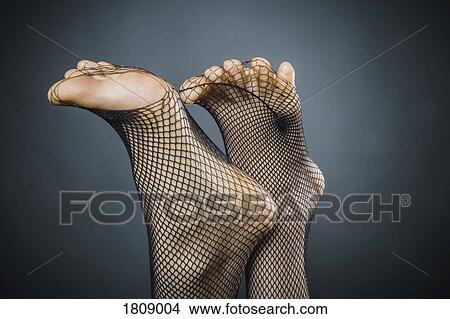 Womans feet poking through fishnet stockings View Large Photo Image Picture - Womans feet poking through fishnet stockings. Fotosearch