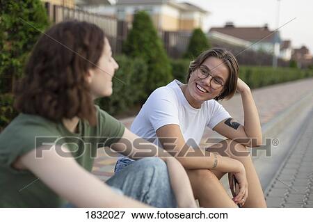 Women friends talking on neighborhood curb View Large Photo Image Stock Photo - Women friends talking on neighborhood curb. Fotosearch