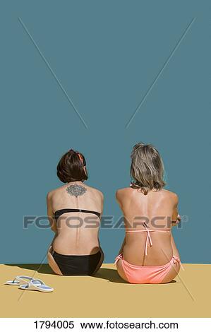 Women in bikinis sunbathing on green background View Large Photo Image Stock Photography - Women in bikinis sunbathing on green background. Fotosearch