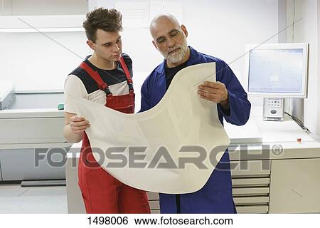Workers checking quality of paper at printing press View Large Photo Image Stock Photograph - Workers checking quality of paper at printing press. Fotosearch