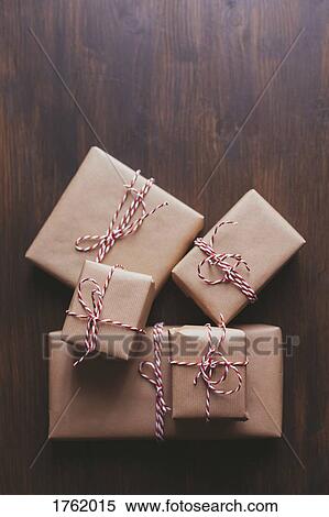 Wrapped Christmas presents on wooden background View Large Photo Image Stock Photography - Wrapped Christmas presents on wooden background. Fotosearch