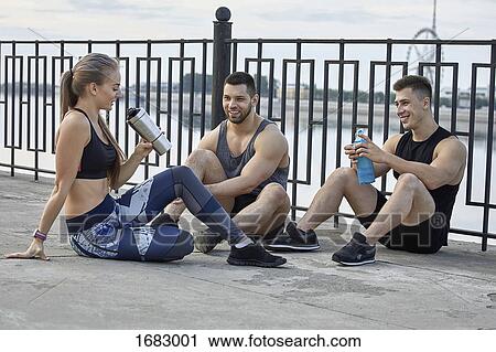 Young athletes resting on footpath by railing View Large Photo Image Stock Image - Young athletes resting on footpath by railing. Fotosearch