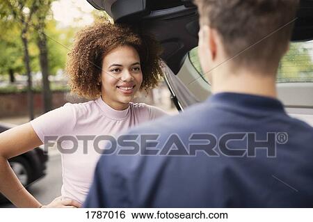 Young couple talking at car View Large Photo Image Stock Photograph - Young couple talking at car. Fotosearch