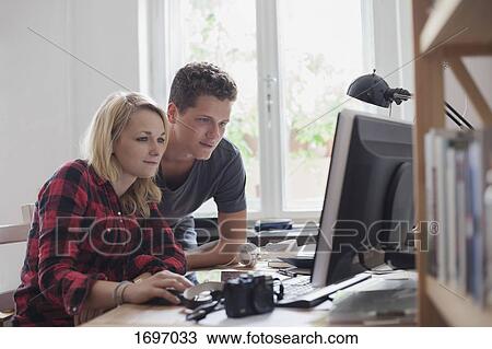 Young couple using computer against window at home View Large Photo Image Stock Image - Young couple using computer against window at home. Fotosearch