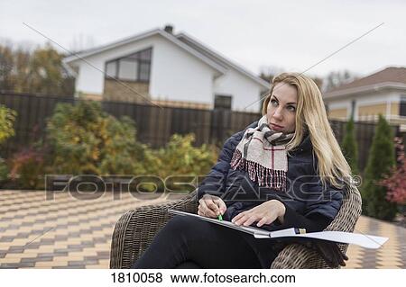 Young female artist sketching on patio View Large Photo Image Stock Photo - Young female artist sketching on patio. Fotosearch