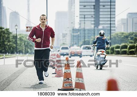 Young man jogging on urban street, Tokyo, Japan View Large Photo Image Stock Photo - Young man jogging on urban street, Tokyo, Japan. Fotosearch