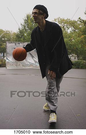 Young man playing basketball at park View Large Photo Image Stock Image - Young man playing basketball at park. Fotosearch