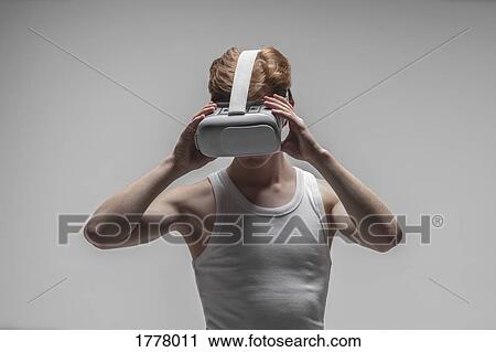 Young man using virtual reality simulator glasses View Large Photo Image Stock Image - Young man using virtual reality simulator glasses. Fotosearch