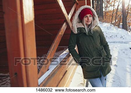 Young woman looking away while leaning on cabin View Large Photo Image Stock Image - Young woman looking away while leaning on cabin. Fotosearch