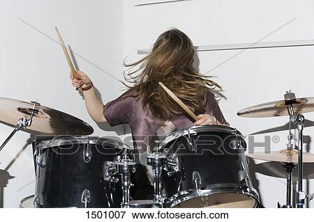 Stock Photo - Young woman playing drums. Fotosearch