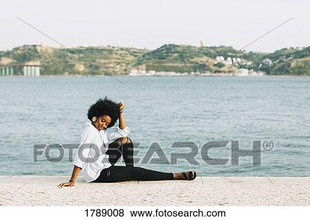 Young woman relaxing at River Tejo waterfront, Belem, Lisbon, Portugal View Large Photo Image Stock Photo - Young woman relaxing at River Tejo waterfront, Belem, Lisbon, Portugal. Fotosearch