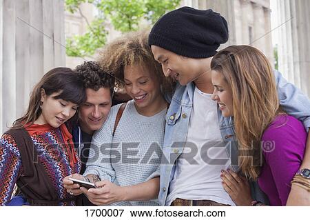 Young woman showing mobile phone to friends View Large Photo Image Stock Photo - Young woman showing mobile phone to friends. Fotosearch