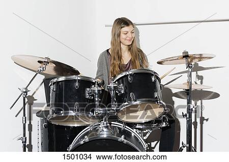Young woman smiling while playing drums View Large Photo Image Picture - Young woman smiling while playing drums. Fotosearch