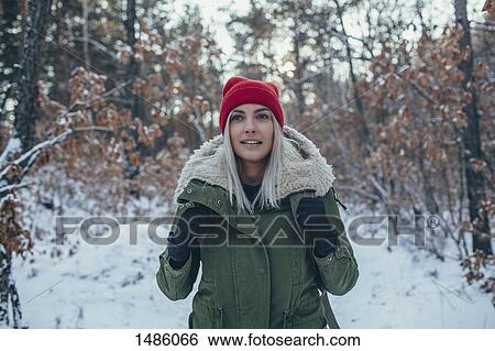 Stock Photograph - Young woman wearing knit hat and jacket while looking away. Fotosearch