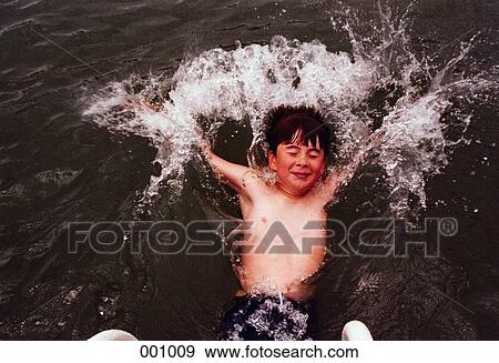 a young boy splashing in the water View Large Photo Image Stock Photo - a young boy splashing in the water. Fotosearch