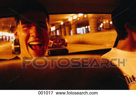 a young man laughing in the backseat of a car View Large Photo Image Stock Photo - a young man laughing in the backseat of a car. Fotosearch