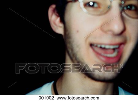 Stock Image - a young man with glasses, smiling. Fotosearch