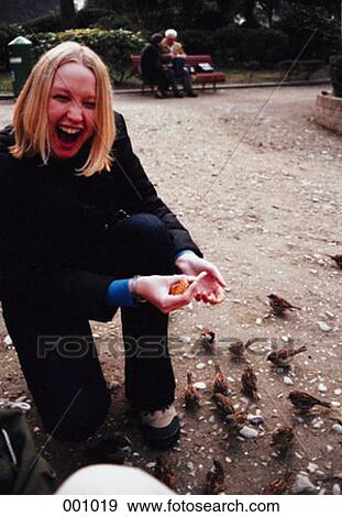 a young woman feeding bread to birds, laughing View Large Photo Image Stock Photo - a young woman feeding bread to birds, laughing. Fotosearch