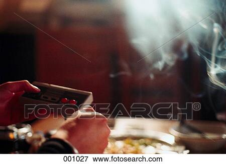 hands holding video game joystick in smoke-filled room View Large Photo Image Stock Photo - hands holding video game joystick in smoke-filled room. Fotosearch