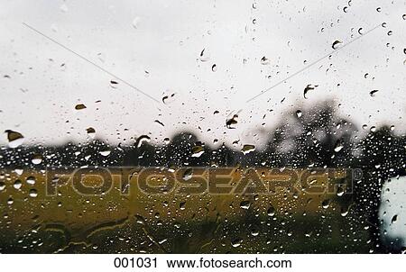 Stock Image - raindrops on a window looking out to the countryside. Fotosearch