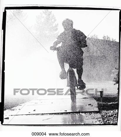 boy cycling in rain View Large Photo Image Picture - boy cycling in rain. Fotosearch