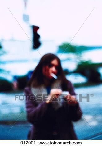 Stock Image - girl lighting cigarette. Fotosearch