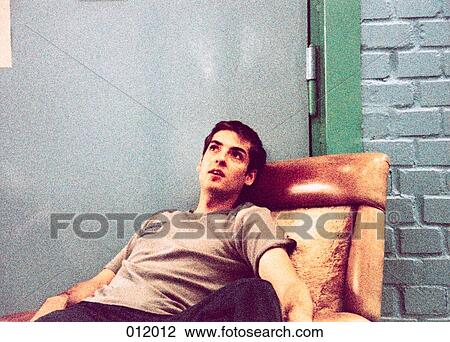 man relaxing on a chair View Large Photo Image Stock Image - man relaxing on a chair. Fotosearch