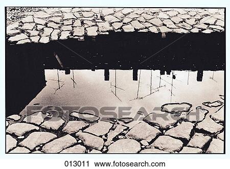 Stock Image - television antennes reflected in puddle. Fotosearch