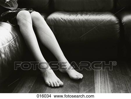 the legs and feet of a woman sitting on a sofa View Large Photo Image Picture - the legs and feet of a woman sitting on a sofa. Fotosearch