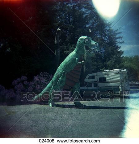 A statue of a dinosaur in a parking lot next to a camper View Large Photo Image Stock Photo - A statue of a dinosaur in a parking lot next to a camper. Fotosearch