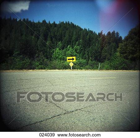 A street sign with an arrow pointing down a road View Large Photo Image Stock Photo - A street sign with an arrow pointing down a road. Fotosearch