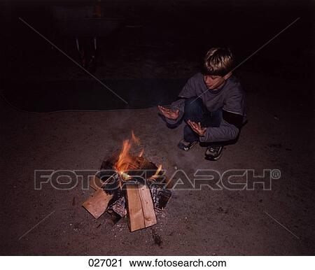 A boy next to a campfire View Large Photo Image Stock Image - A boy next to a campfire. Fotosearch