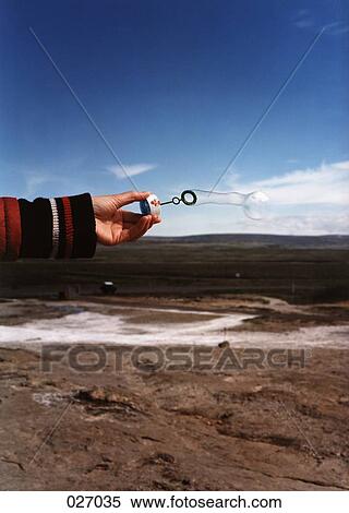 A hand holding a bubble dispenser with the ocean in the background View Large Photo Image Stock Photography - A hand holding a bubble dispenser with the ocean in the background. Fotosearch