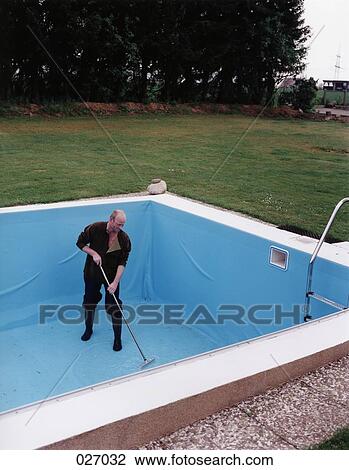A man cleaning an emptied swimming pool View Large Photo Image Stock Image - A man cleaning an emptied swimming pool. Fotosearch